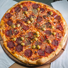 Delicious pizza topped with olives, mushrooms, and ham slices