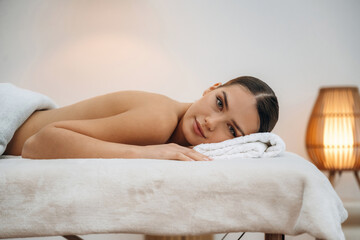 Obraz premium Beautiful young woman lying on a couch in a spa salon