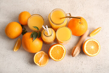 Glasses and bottle of fresh orange juice with wooden juicer on white background