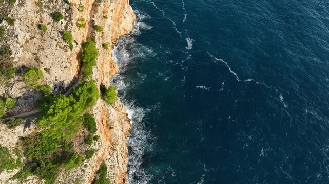 Aerial Tilt Up Reveal of Sunny Rugged Mediterranean Coastline and Sea