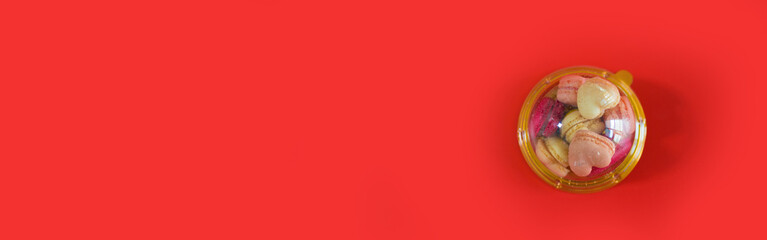 flat lay heart shape of macarons on red background