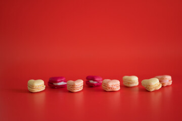 flat lay heart shape of macarons on red background