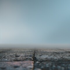 A serene, foggy landscape with a wooden surface leading to a blurred horizon.