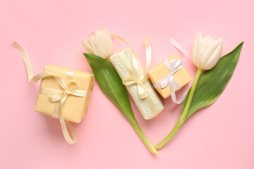 Composition with gift boxes and tulip flowers on pink background
