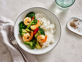 A vibrant dish showcasing succulent shrimp stir fried with fresh broccoli and served over fluffy white rice. This meal creates a delightful dining atmosphere