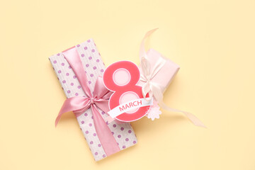 Composition with greeting card and gift boxes for Women's Day celebration on beige background