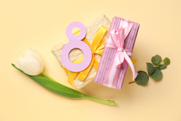 Gift boxes, figure 8 made of paper and tulip flower for Women's Day celebration on beige background
