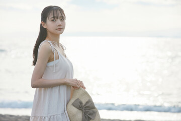 海辺を散策する若い女性