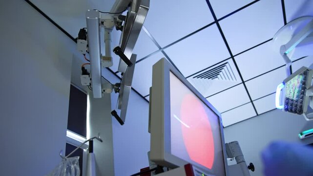 One of the monitors in modern surgery room displays endoscopic operation. Low angle view at the equipment in operational theatre.