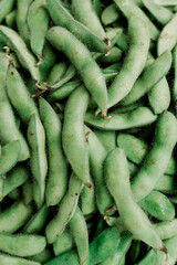Fresh edamame pods as background, closeup view