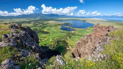 Panoramic view of lake, mountains, and valley from rocky outcrop. Ideal for travel brochures