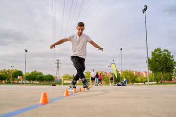 Man performing a rollerblading slalom through cones in an outdoor park