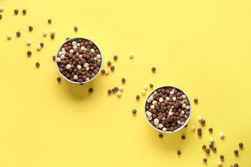 Bowls with tasty corn balls on yellow background