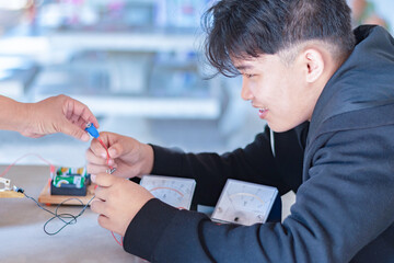 Children are studying electrical circuit systems by experimenting with electrical connections using...