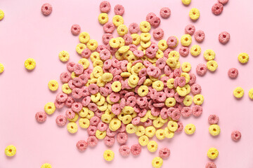 Scattered color cereal rings on pink background