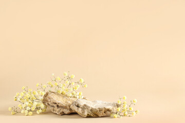 Beautiful gypsophila flowers and decorative stones on beige background