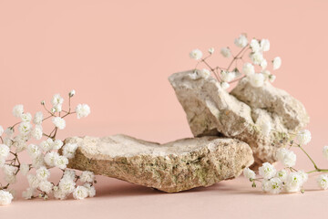 Beautiful gypsophila flowers and decorative stones on beige background, closeup