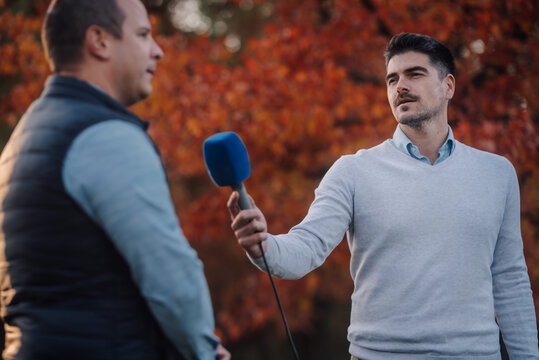 Journalist interviewing golf player in autumn
