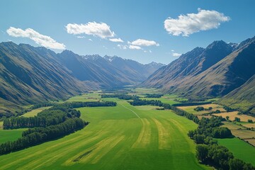 Vibrant valley landscape with towering mountains and lush greenery under a clear blue sky in daytime