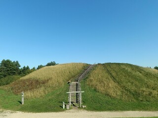 Salduve hill during sunny day. Small hill. Grass is growing on hill. Staircase leading to the top....