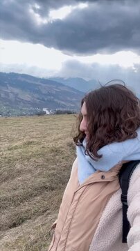 Embracing nature while walking on a serene path in the mountains during cloudy weather