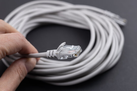 RJ-45 crimped red ethernet connector, unshielded twisted pair UTP internet cable end in hand