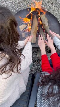 Friends enjoy warmth by a cozy fire on a chilly evening outdoors