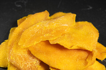 Sliced Dried Mango, Dried Fruit. Candied fruits, mango pieces. Heap of candied slices, crystallized fruit