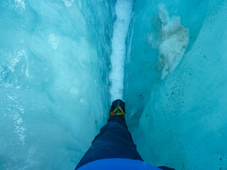 Hiker navigates narrow crevasse on Franz Josef Glacier, Westland Tai Poutini National Park, South...