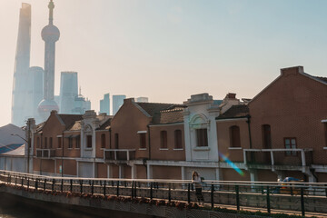 Fototapeta premium woman traveler visiting in Shanghai, China. Female Tourist with backpack sightseeing Shanghai view of Lujiazui in Hongkou Gang canal of Shanghai. landmark and popular for tourism attraction