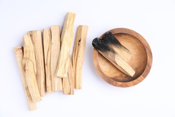 Whole and burnt palo santo sticks on white background, flat lay