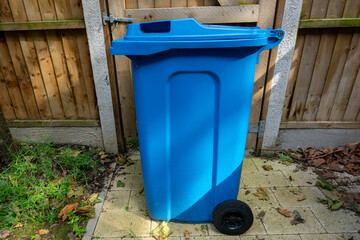 Obraz premium Blue Wheeled Recycling Bin in a Backyard