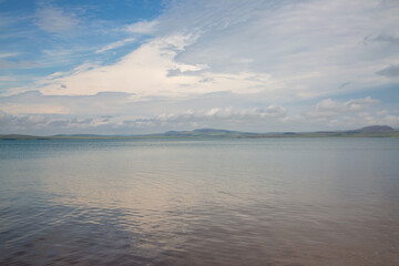 Natural background of lake water, sky and shore in the background