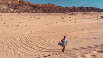 man sandboarding colored canyon in the Sinai desert in Egypt