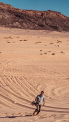 man sandboarding colored canyon in the Sinai desert in Egypt