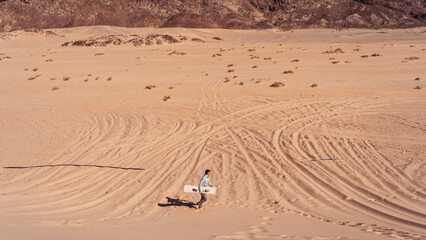 man sandboarding colored canyon in the Sinai desert in Egypt