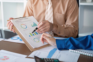 Accountants reviewing monthly budget metrics and performance charts in a sleek office