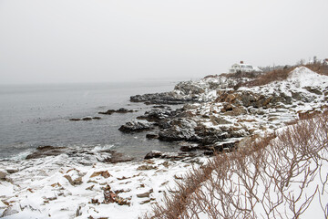 winter view of the Atlantic Ocean coast. Rocky shore in the snow. USA. Maine.