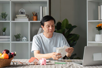 Concerned man facing financial problems and expenses while checking his smartphone at home