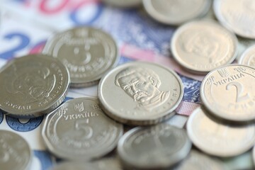 Ukraine money coins lying on mixed hryvnia banknotes. Finance background concept.
