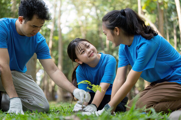 Fototapeta premium Volunteers family planting trees together in a park for environmental conservation