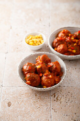 Homemade meatballs with hot sauce and corn