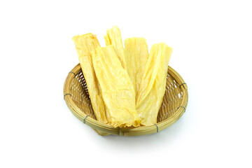 Group of dried Tofu skin (Yuba, beancurd skin, beancurd sheet or beancurd robes) in wooden basket isolated on white background close up stack, chips in a bowl