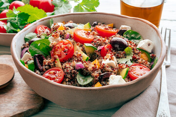 Quinoa salad, healthy Mediterranean lunch with fresh organic vegetables, cheese, and olives