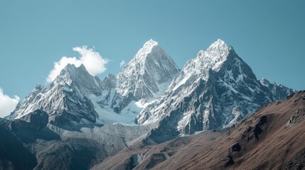 Fototapeta premium Majestic mountain peaks displaying rugged beauty against a clear blue sky with snow-capped summits and dramatic landscapes.