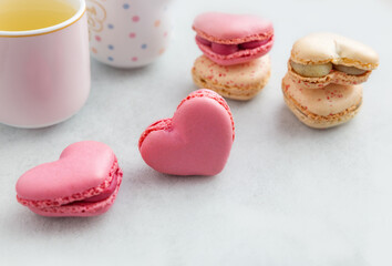 Romantic dessert - colorful heart-shaped macarons on light background with bokeh and copy space . A beautiful composition for sweets and holiday themes. Valentine's day, mother's day, congratulations.