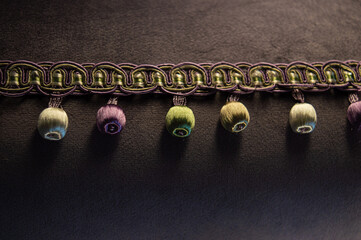 a dark fabric photo with a velvety surface and bumbones on the fringe. Beautiful background on the...