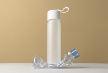 No plastic, Zero Waste, Sustainable Lifestyle. Choice Plastic Free Items alternative to disposable. Crumpled plastic bottle and glass bottle on beige background.