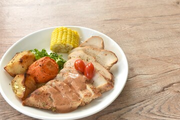 grilled slice chicken steak dressing gravy sauce with lettuce and boiled potato couple corn on plate 
