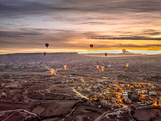 Aerial drone view of numerous hot air balloons floating in the sky above Göreme in Cappadocia